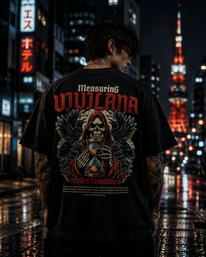 Black graphic tee with skull, hourglass, and crows design, worn in neon-lit city at night