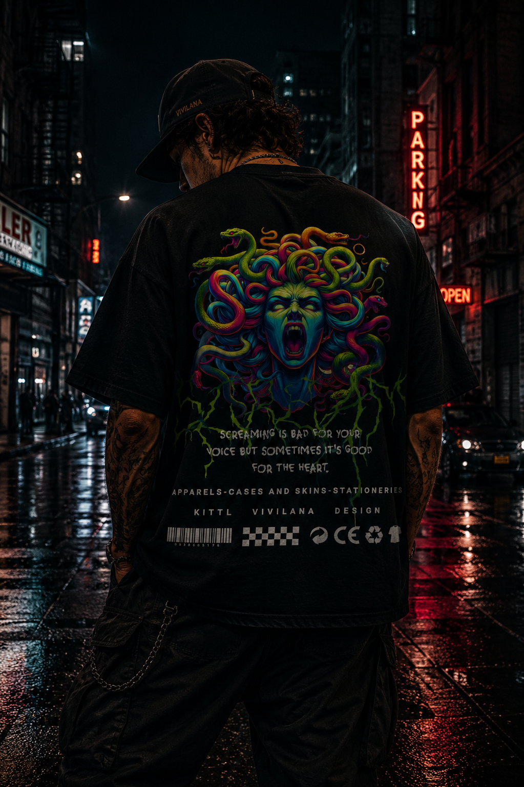 Man wearing black graphic tee with colorful Medusa design, urban night street backdrop